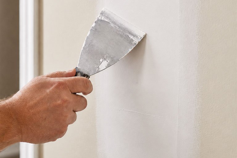 Applying joint compound to a drywall patch with a putty knife