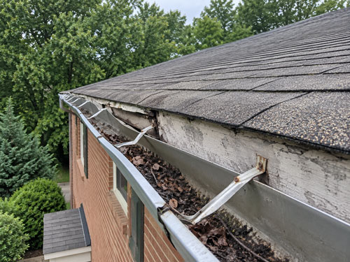 A sagging gutter with debris in it